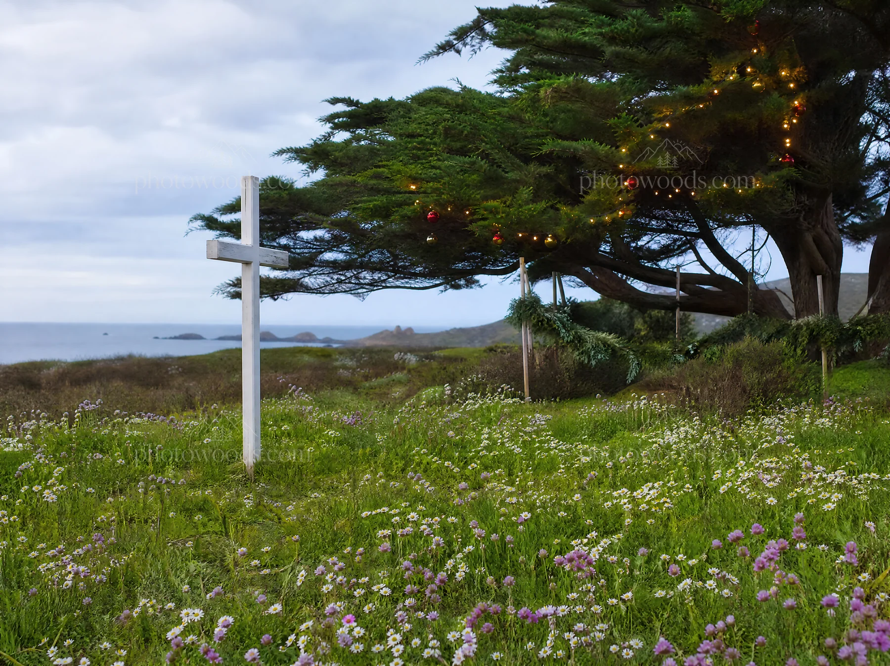 White Christian cross in wildflower meadow by the sea - AI-generated stock image