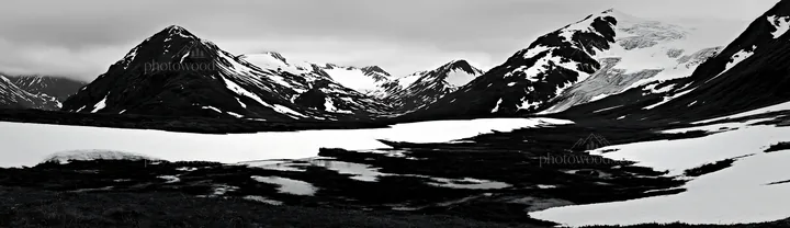 Snowmelt meadow with mountains in black and white landscape - AI-generated stock image